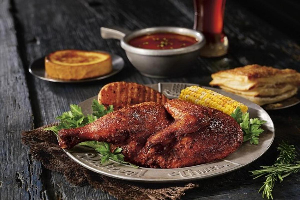 Un plato de pollo y maíz en una mesa.