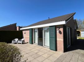 Knusse bungalow met omheinde tuin met veranda, Hotel in Tzummarum