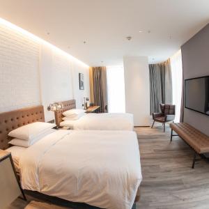 Corner guest room with two double beds and city view