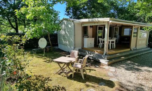 Mobile home avec terrasse et piscine.