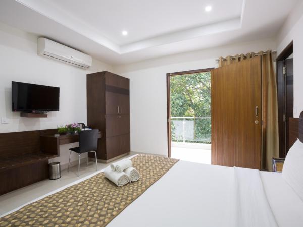 Sanctum Suites BEL Road Bangalore : photo 1 de la chambre chambre lit king-size avec balcon