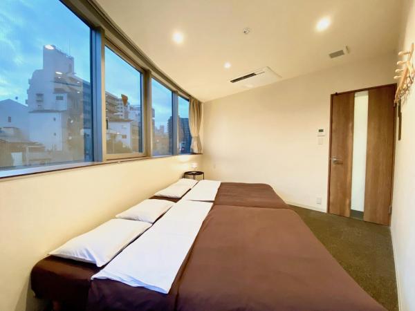 Osaka Guesthouse Nest : photo 2 de la chambre chambre lits jumeaux avec 2 lits doubles et salle de bains commune