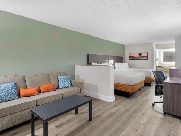 Quality Inn & Suites Orlando East - UCF Area : photo 3 de la chambre suite lit king-size avec canapé - accessible aux personnes à mobilité réduite - non-fumeurs