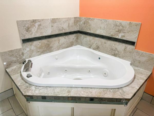 Pecan Valley Inn & Suites : photo 1 de la chambre suite lit king-size avec baignoire spa