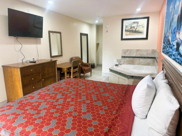Pecan Valley Inn & Suites : photo 3 de la chambre suite lit king-size avec baignoire spa
