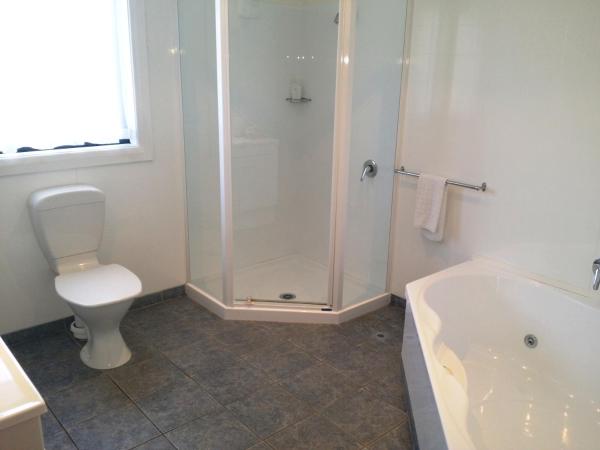 Fairway Motel & Apartments : photo 9 de la chambre suite lit king-size avec baignoire spa