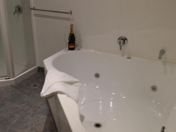 Fairway Motel & Apartments : photo 5 de la chambre suite lit king-size avec baignoire spa