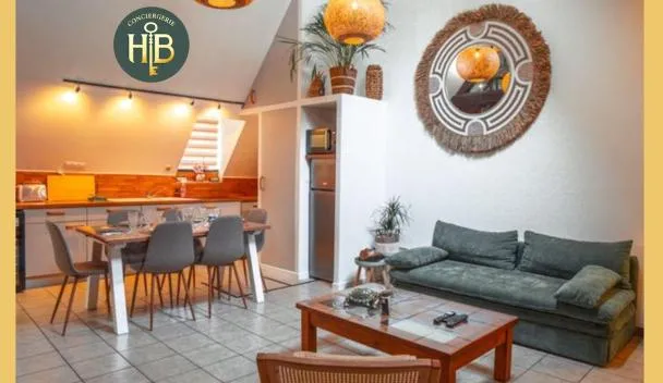 Open-plan living/dining with dining table, sofa, wall mirror, Wi-Fi and Netflix icons, and HB Conciergerie sign at Bali Surya in Chalon-sur-Saône