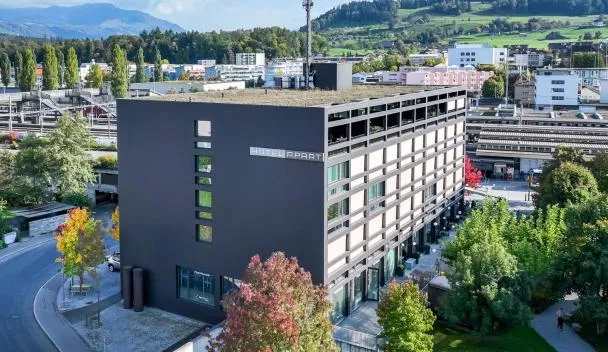 Modern six-story Hotel APART with rooftop terrace, glass-fronted entrance and on-site parking near train station and mountains at HOTEL APART - Welcoming l Urban Feel l Design in Rotkreuz