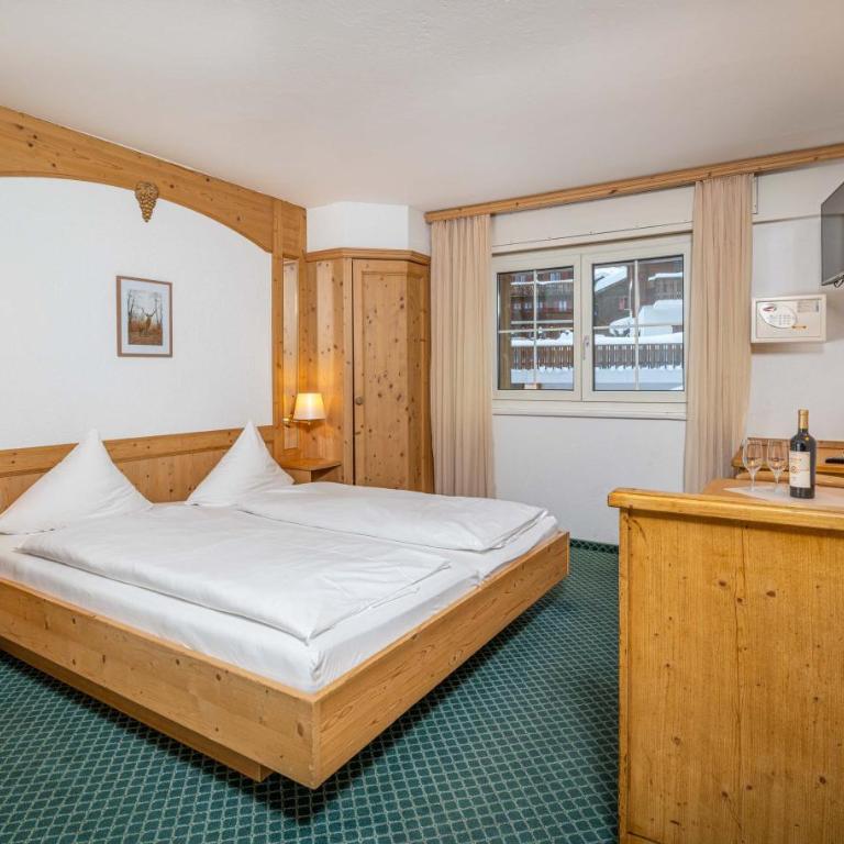 Grichting Hotel & Serviced Apartments - Zimmer mit Kingsize-Bett und Bergblick - 5