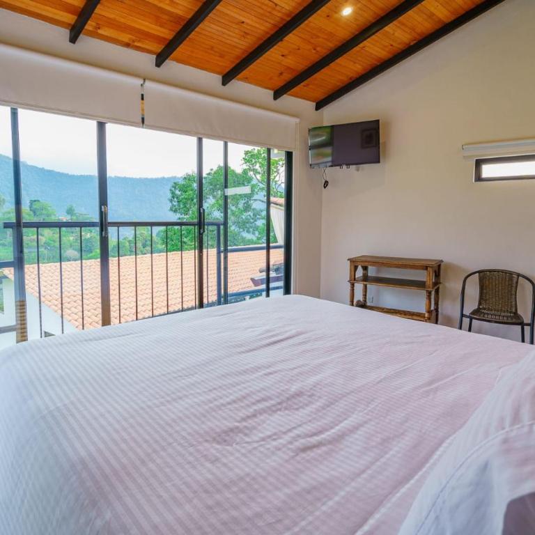 Acaima Café Lodge - Habitación con cama grande y vistas al jardín - 8