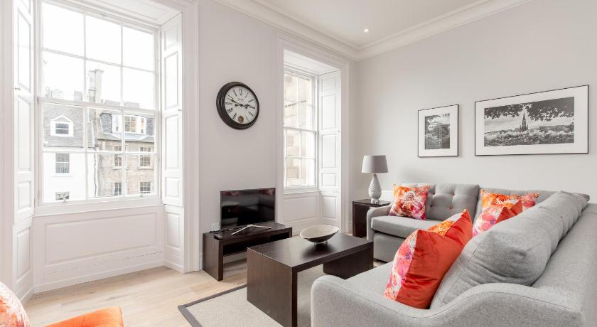 a living room filled with furniture and a large window, Destiny Scotland - Chisholm Hunter Suites in Edinburgh
