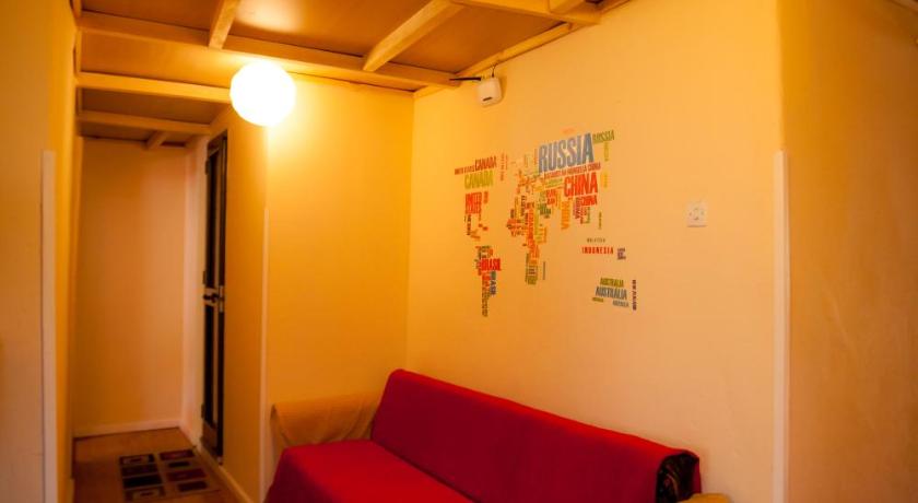a living room with a red couch and a red wall, The Wanderers Hostel in Shkoder