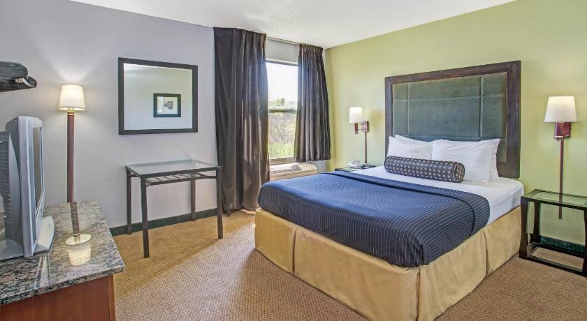 a hotel room with a large bed and a large window, Days Inn by Wyndham Great Lakes - N. Chicago in Great Lakes