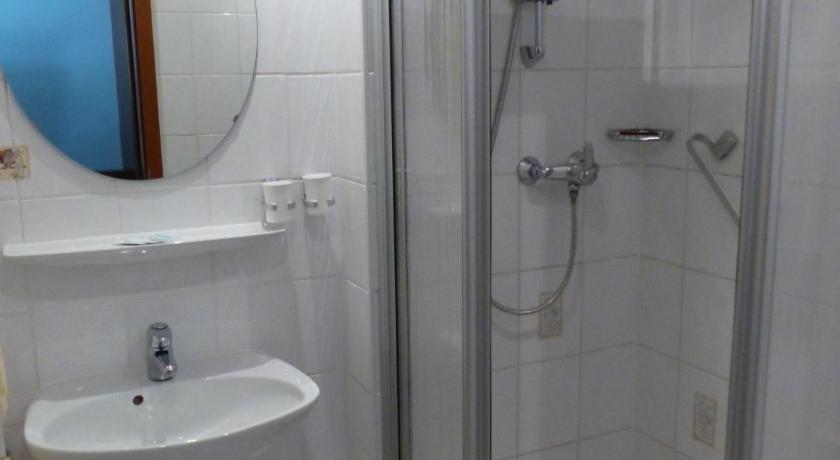 a bathroom with a shower, toilet, and sink, Hotel Dorotheenhof in Cottbus