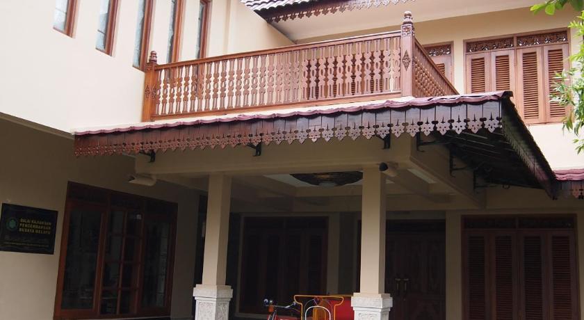 a large white building with a patio area, Balai Melayu Hotel in Yogyakarta
