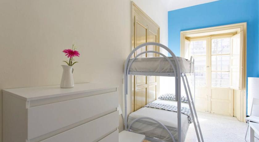 a bedroom with a bed and a dresser, Sunshine Hostel in Palermo