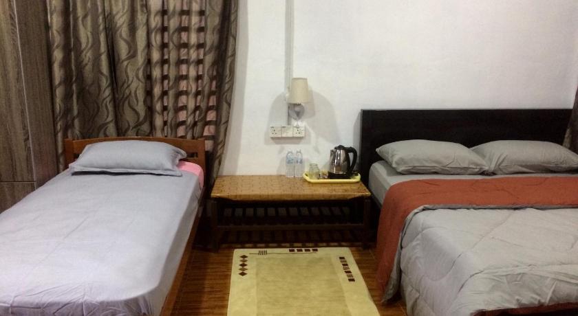 a room with a bed, a desk and a lamp, Roomstay Zulmi in Arau