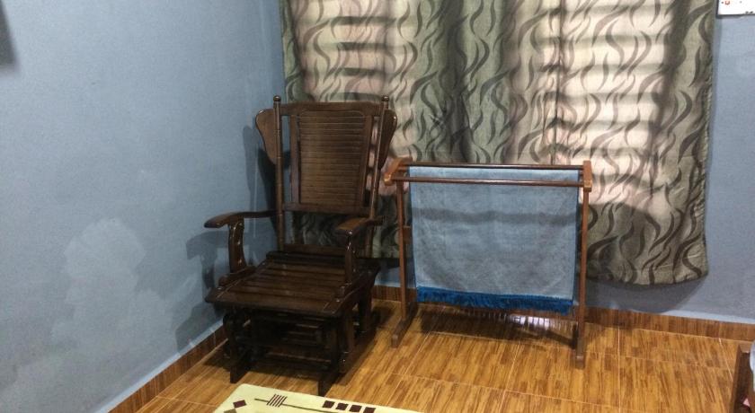 a living room filled with furniture and a chair, Roomstay Zulmi in Arau