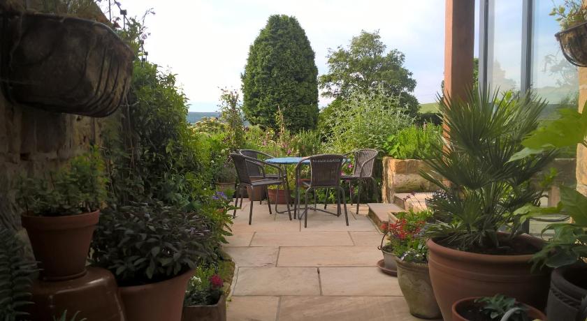 a garden area with a table, chairs, and plants, Thorpe Green House Vegetarian Bed and Breakfast in Whitby