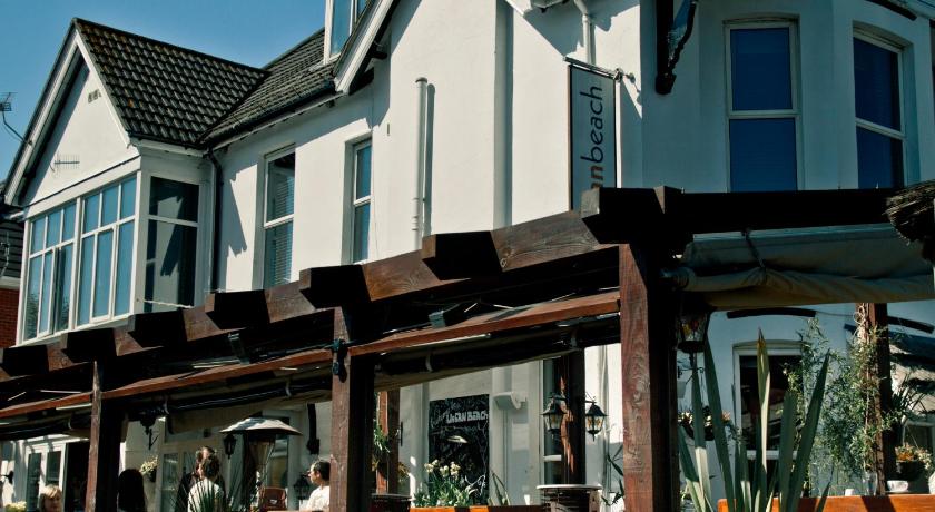 a row of wooden benches in front of a building, Urban Beach Hotel in Bournemouth