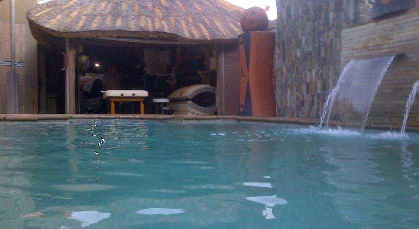 a swimming pool with a tub and a chair in front of it, Die Bostokelos and Spa in Vanderbijlpark