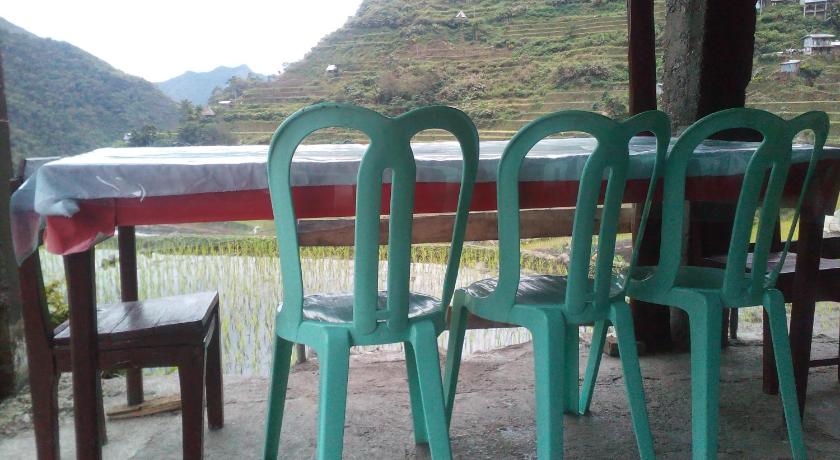 two green chairs sitting next to each other on a bench, BATAD CRISTINA'S Main Village INN & Restaurant in Banaue