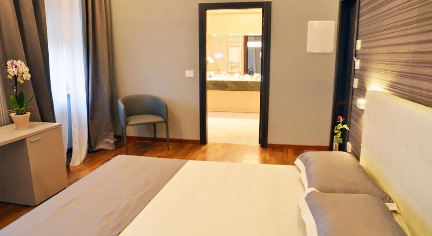 a bedroom with a bed, chair and a window, Borea Luxury B&B in Pescara