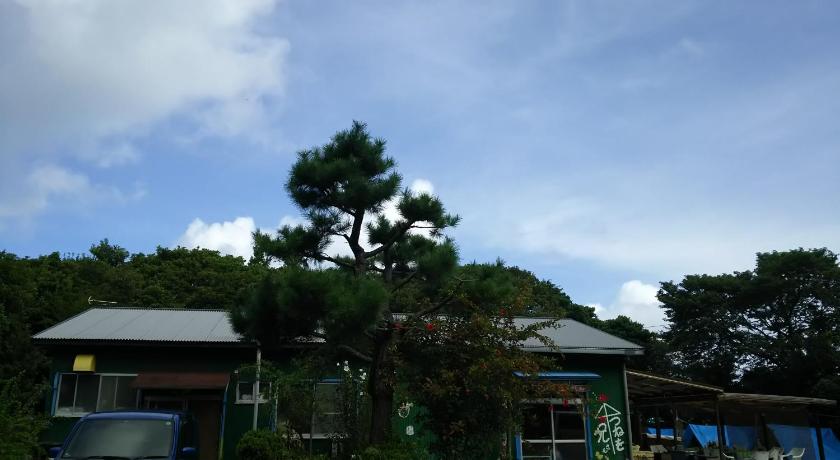 a green and white building with trees, Tomarigi in Yakushima