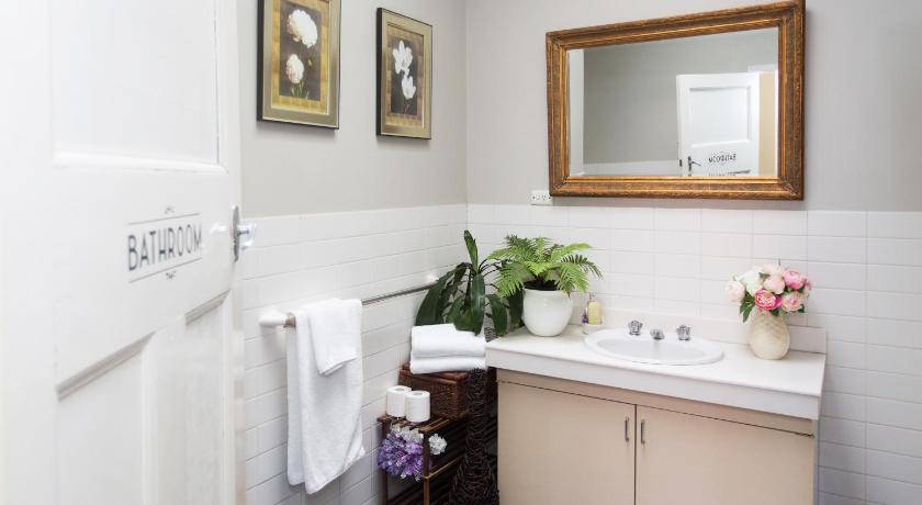 a bathroom with a sink, mirror, and toilet, Southern Railway Hotel Goulburn in Goulburn