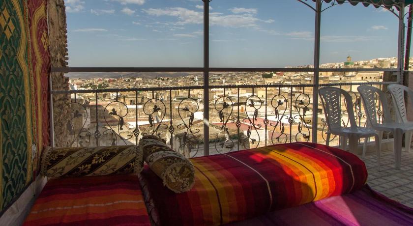 a hotel room with a bed, table, and balcony, Riad Diwan in Fes