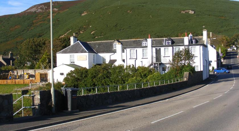 a white house on a hillside next to a road, Belgrave Arms Hotel in Helmsdale