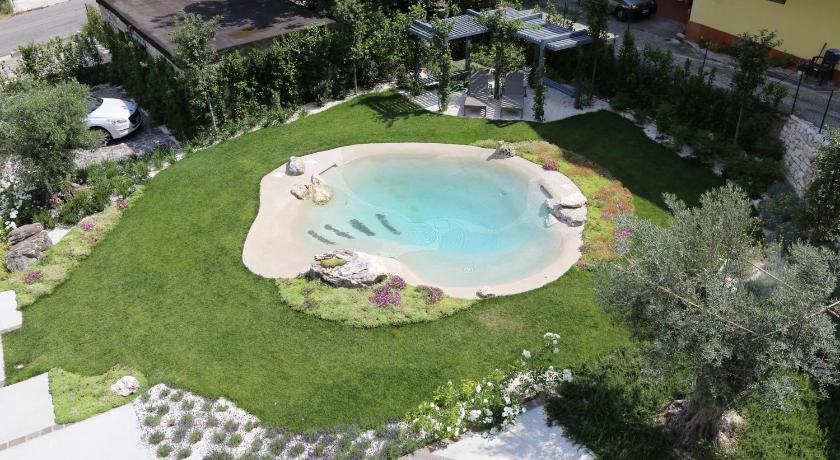 a green lawn with a pool and lawn chairs, B&B Dei Raselli in Guardiagrele