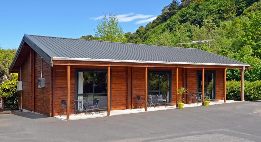 a large white building with a wooden roof, Leith Valley Holiday Park and Motels in Dunedin