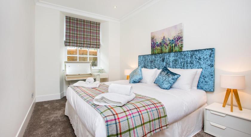 a bed room with a white bedspread and white pillows, Blythswood Square Apartments in Glasgow