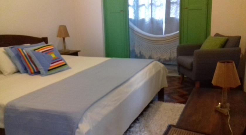 a bedroom with a bed, chair and a lamp, Pousada Baluarte in Salvador