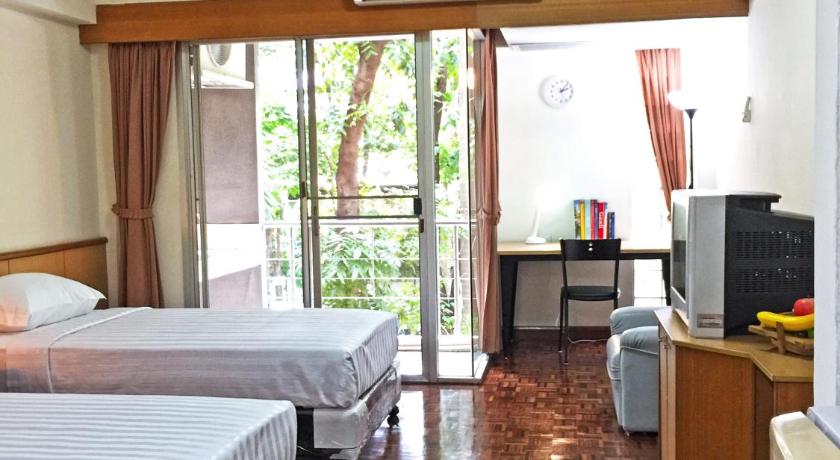 a hotel room with a bed and a television, RIO MONTE RESIDENCE in Bangkok