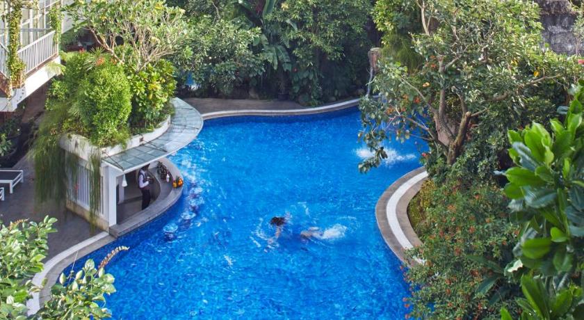 a swimming pool with a large blue and white swimming pool, Jambuluwuk Malioboro Hotel Yogyakarta in Yogyakarta