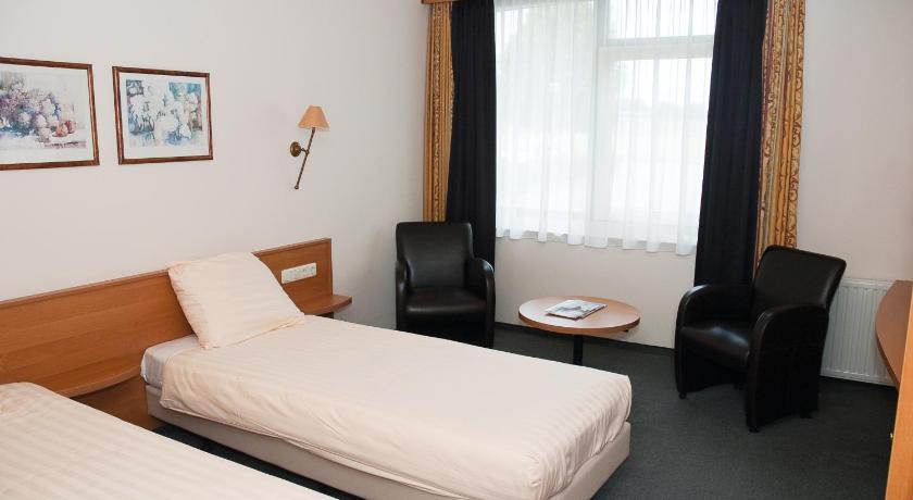 a hotel room with two beds and a desk, Fletcher Hotel - Restaurant Steenwijk in Steenwijk