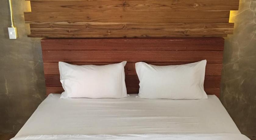 a bed with a white comforter and pillows, De Nan Hotel in Nan