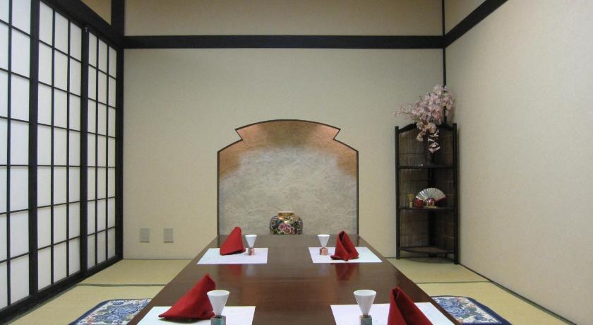 a dining room table with two chairs and a vase of flowers, Saku Grand Hotel in Saku