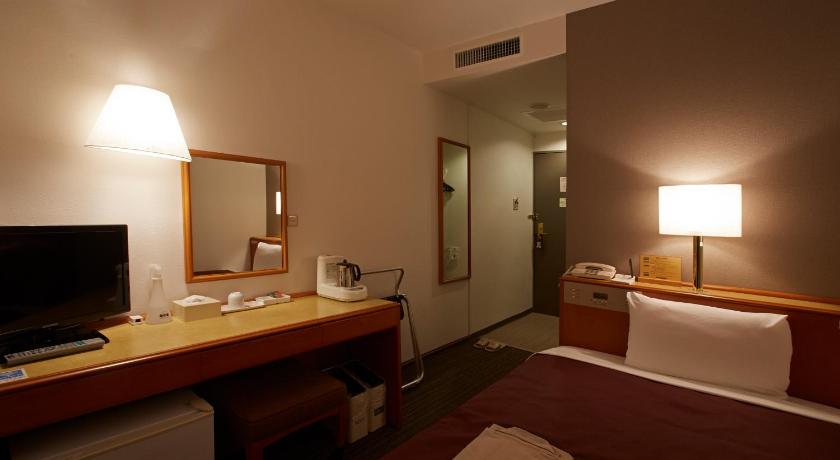 a hotel room with two beds and a television, Country Hotel Takayama in Takayama