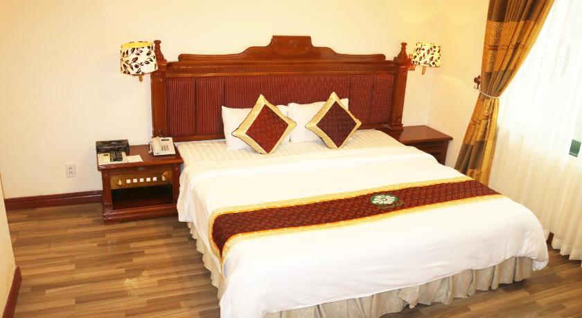 a hotel room with a bed and a dresser, Central Hotel in Quang Ngai
