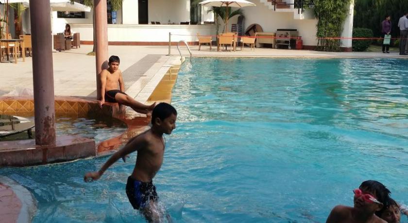 two people in a pool playing with a frisbee, Club Denovo in Butwal