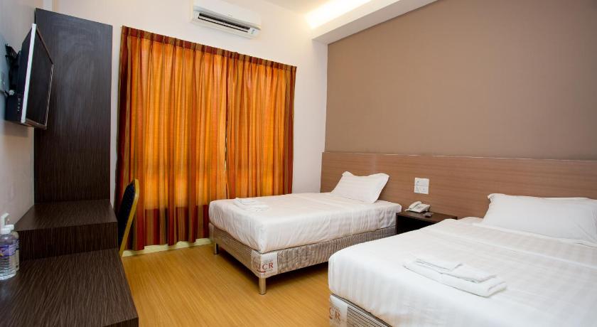 a hotel room with two beds and a television, Labuan Fortune Hotel in Labuan