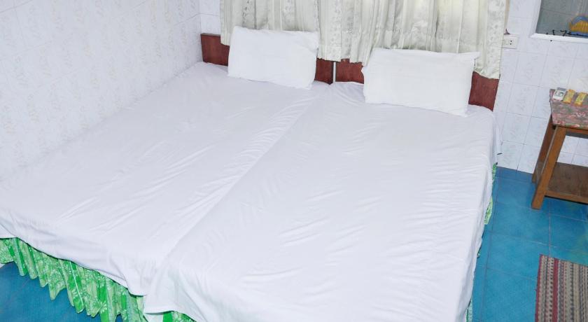 a bed with white sheets and pillows in a room, A.D.1 Hotel in Mandalay
