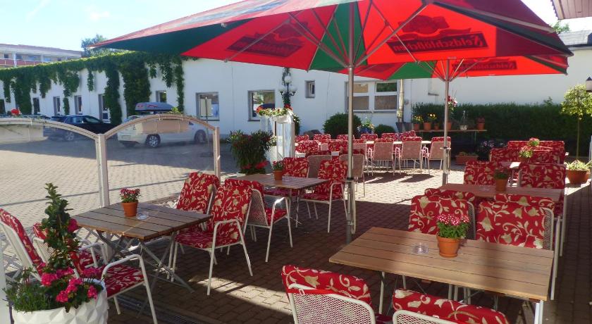 a patio area with tables, chairs and umbrellas, Hotel Dorotheenhof in Cottbus