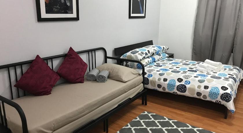 a bed room with two beds and a couch, MayTower Serviced Apartment in Kuala Lumpur