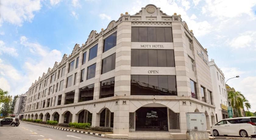 a large building with a clock on the side of it, Moty Hotel in Malacca