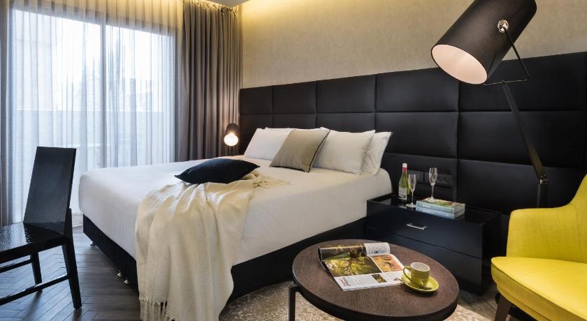 a hotel room with a bed and a desk, Leonardo Boutique Jerusalem in Jerusalem